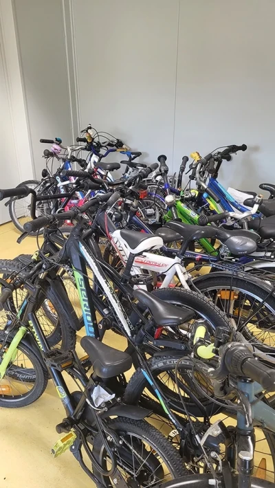 Eine große Gruppe von Kinderfahrrädern, dicht nebeneinander geparkt.