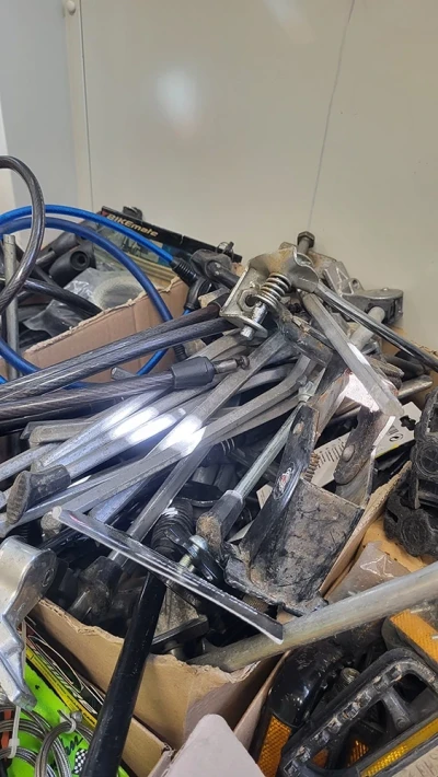 Eine Kiste mit gebrauchten Fahrradständern und anderen Ersatzteilen.