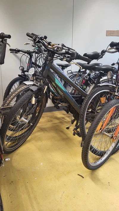 Mehrere Fahrräder stehen eng aneinandergestellt in einer Ecke des Raums.